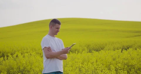 Farmer Using Tablet Computer In Rapeseed Cultivated Field Stock Footage 89679633