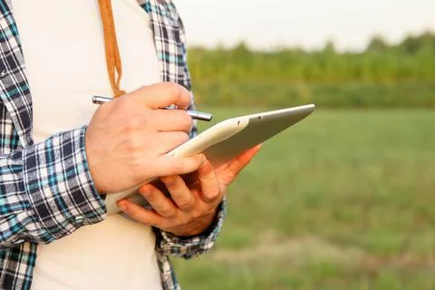 A farmer using a tablet in a farm field. farmer with tablet agriculture AI... Foto stock