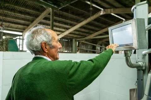 Farmer using touch screen computer in barn managing farm operations Stock Photos