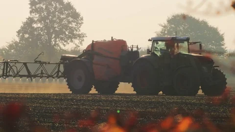 Farmer using a tractor to spray his field, tractor watering seedlings Stock Footage 119921419