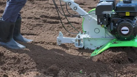 Farmer Using a Walk-Behind Cultivator in a Field Stock Footage 309530501