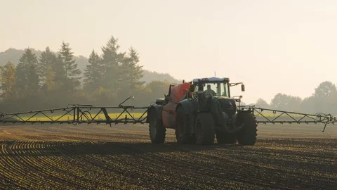 Farmer using a watering tractor to spray his field for weeds and insects Stock Footage 119922883