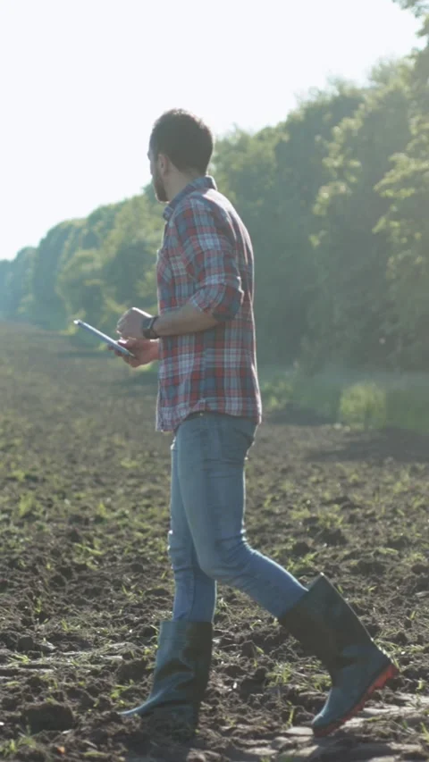 A Farmer Utilizing Advanced Technology Effectively in the Agricultural Field Stock Footage 314958634