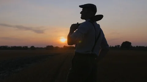 A farmer walking across the field greets the others. Stock Footage 113177984