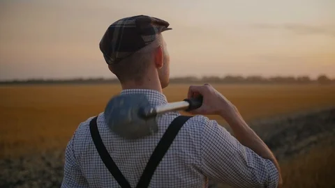 A farmer walking in the field, throwing a shovel on his shoulders Stock Footage 113177935