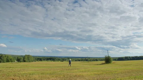 Farmer walking in mown field. Distant view of gardener working in farmland Video stock 159507262