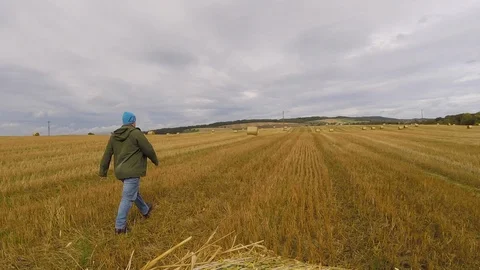 Farmer walking through Scottish field in autumn 動画素材 97002483