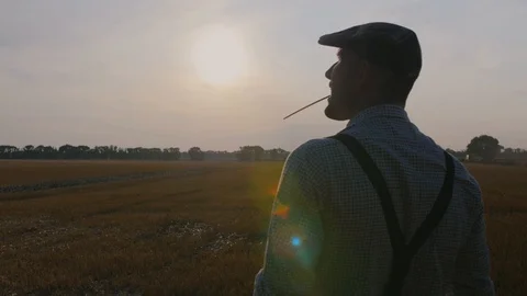 A farmer walks across the field in a hat. Stock Footage 113178089