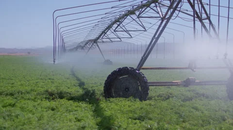 A farmer waters his fields with a modern, mobile sprinkler apparatus. Stock Footage 68287389