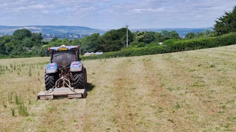 Farmer working with tractor in the fields of Devon from a drone, Torquay Stock-Footage 312800836