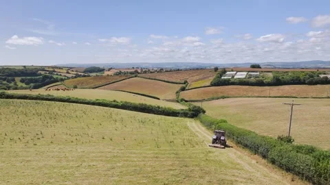 Farmer working with tractor in the fields of Devon from a drone, Torquay Vidéo 312801017