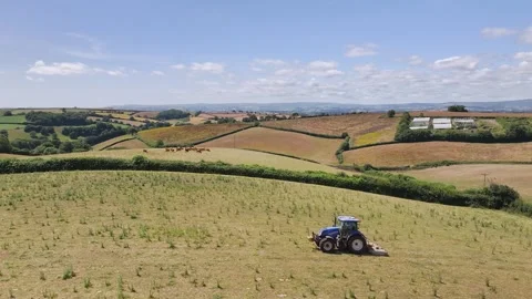 Farmer working with tractor in the fields of Devon from a drone, Torquay Vidéo 312801031