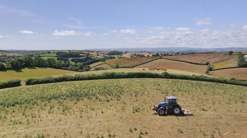 Farmer working with tractor in the fields of Devon from a drone, Torquay Vidéo 312801096