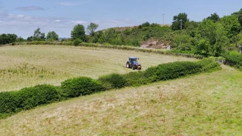 Farmer working with tractor in the fields of Devon from a drone, Torquay Vidéo 312801097