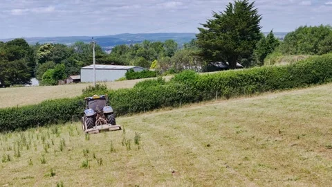 Farmer working with tractor in the fields of Devon from a drone, Torquay Vidéo 312801135