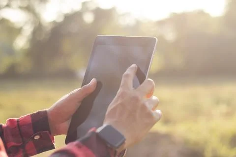 Farmers are using tablets to record data on their farm. Solar farm, smart f.. Stock Photos