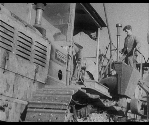 Farmers mulching with trucks at fields, during sunny day, 1942, UK Stock Footage 130672144