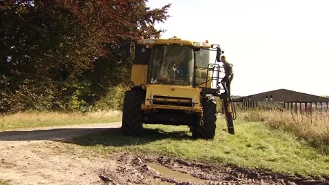 A farming climbing into a Combine Harvester Stock Footage 139455489