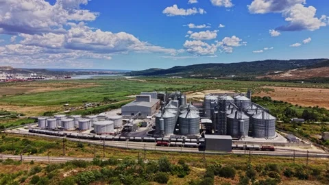 Farming facility with silos and fields under clear skies Stock Footage 341328099