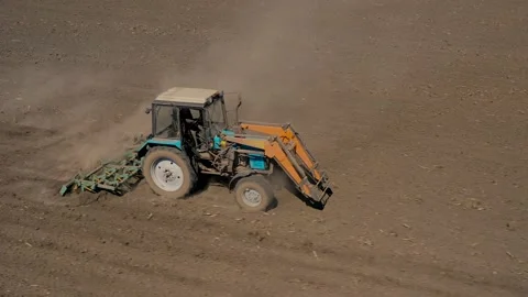 Farming: a farmer on a tractor works the field before sowing Stock Footage 172014390