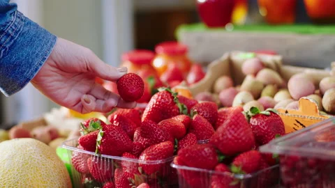 In the farming shop customer pick up some fresh red strawberry from the box Stock Footage 166515854
