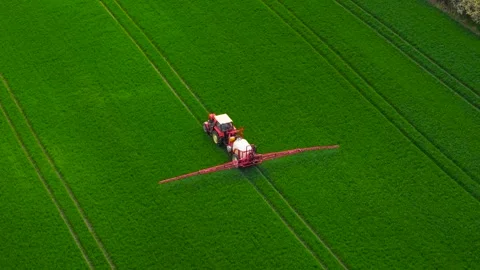 Farming tractor spraying field during seasonal treatment. Agricultural vehicle Stock Footage 312786055