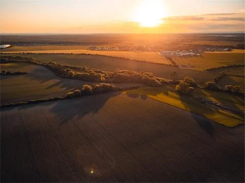 Farmland fields casting long shadows during sunset aerial view over rural l.. 库存照片