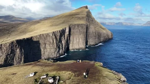 Faroe Islands 4K Drone: Tilting Reveal Over Cliff Edge and Mountain Ridge Stock Footage 313496958