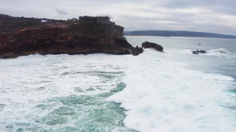 Farol da Nazaré - cliffs with lighthouse washed Atlantic ocean waves crashing Vidéo 315507449