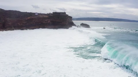 Farol da Nazaré - cliffs with lighthouse washed by Atlantic ocean waves crashing Video stock 327244819