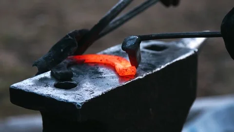 Farrier forges horseshoe in slow motion Stock Footage
