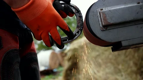 Farrier hand close-up processing of an iron horse shoe Stock Footage 219104342