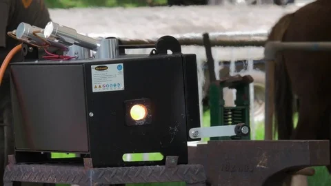 Farriers mobile gas forge gives off heat haze at outdoor craft fair England Stock-Footage 69828037