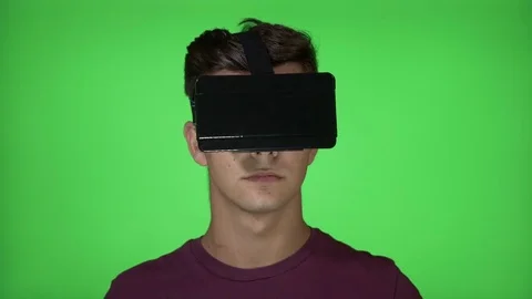 Fascinated young man using a VR headset experiencing virtual reality looking  Stock Footage 83113240