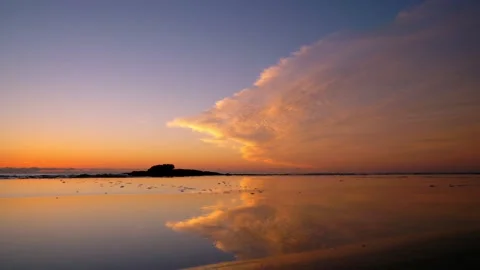 Fascinating clouds are reflected in the shallow water of the coast. Stock Footage 152855869