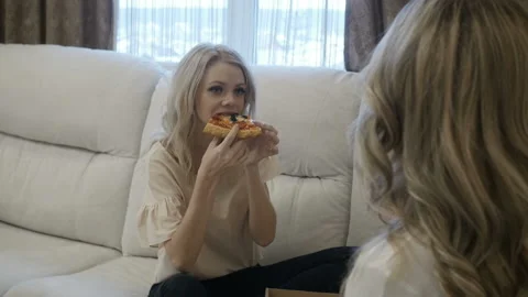 Fascinating girl eats pizza with her girlfriend Stock Footage 85527313