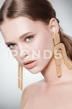 Fashion beauty portrait. Attractive fashion model posing in earrings in the Stock Photos