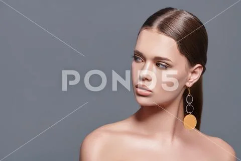 Fashion beauty portrait. Attractive fashion model posing in earrings in the Stock Photos