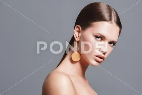 Fashion beauty portrait. Attractive fashion model posing in earrings in the Stock Photos