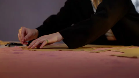 Fashion design process, with the person's hands arranging pattern pieces on Stock Footage 264349222