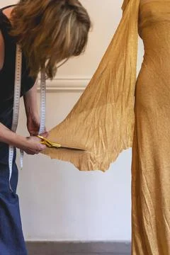 Fashion designer using textile scissors to work on clothing design. Vertica.. Stock Photos