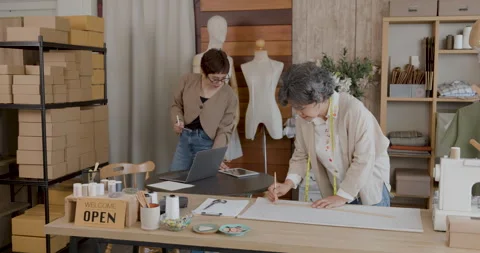 Fashion Designers Collaborating On Apparel Patterns In Atelier Workshop Med.. Stock Footage 336247327