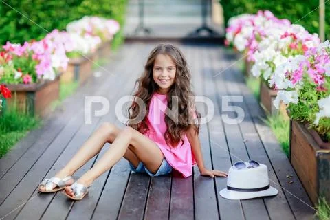 Fashion girl wearing a pink checkered shirt, hat and sunglasses in city Stock Photos
