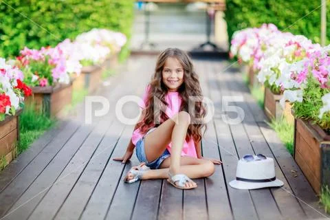 Fashion girl wearing a pink checkered shirt, hat and sunglasses in city Stock Photos