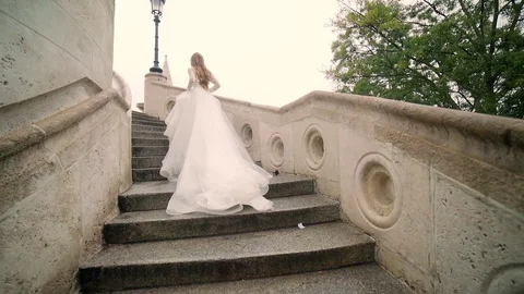Fashion model, the bride in a chic wedding long dress running walks or walks Stock Footage 129507288