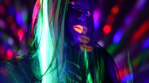 Fashion model girl with colorful fluorescent makeup in ultraviolet neon lights Stock Footage