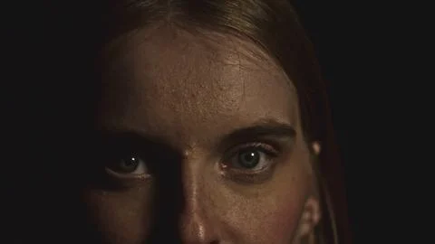 Fashion model posing with dramatic lighting and partially shadowed face Stock Photos