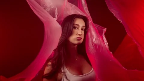 Fashion model posing with flowing red fabric, beauty and art concept, studio Stock Footage 337003975