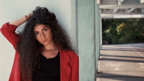 Fashion model posing with hand on long curly brown hair Stock Footage 115711054