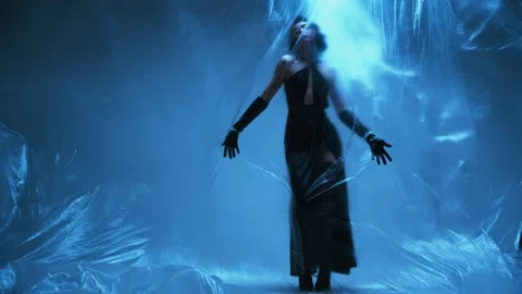 Fashion model posing in studio, dark silhouette dancing with transparent film Stock Footage 310332446
